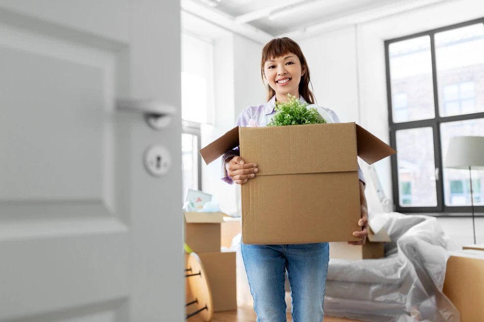 Young woman with moving boxes smiling