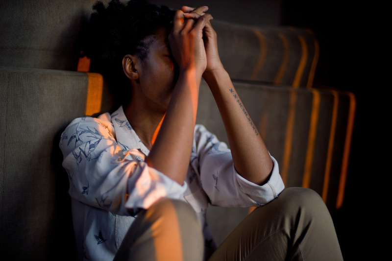 Stressed person sitting with their face in their hands