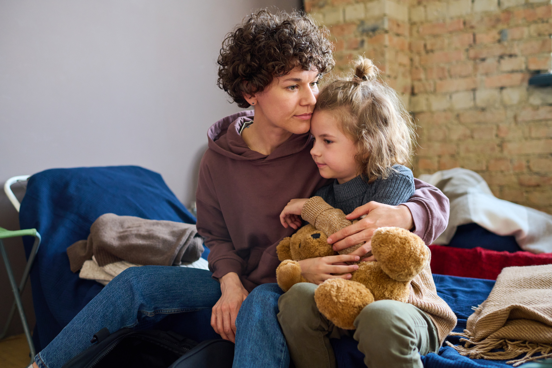 young single mum and her daughter in a bedroom