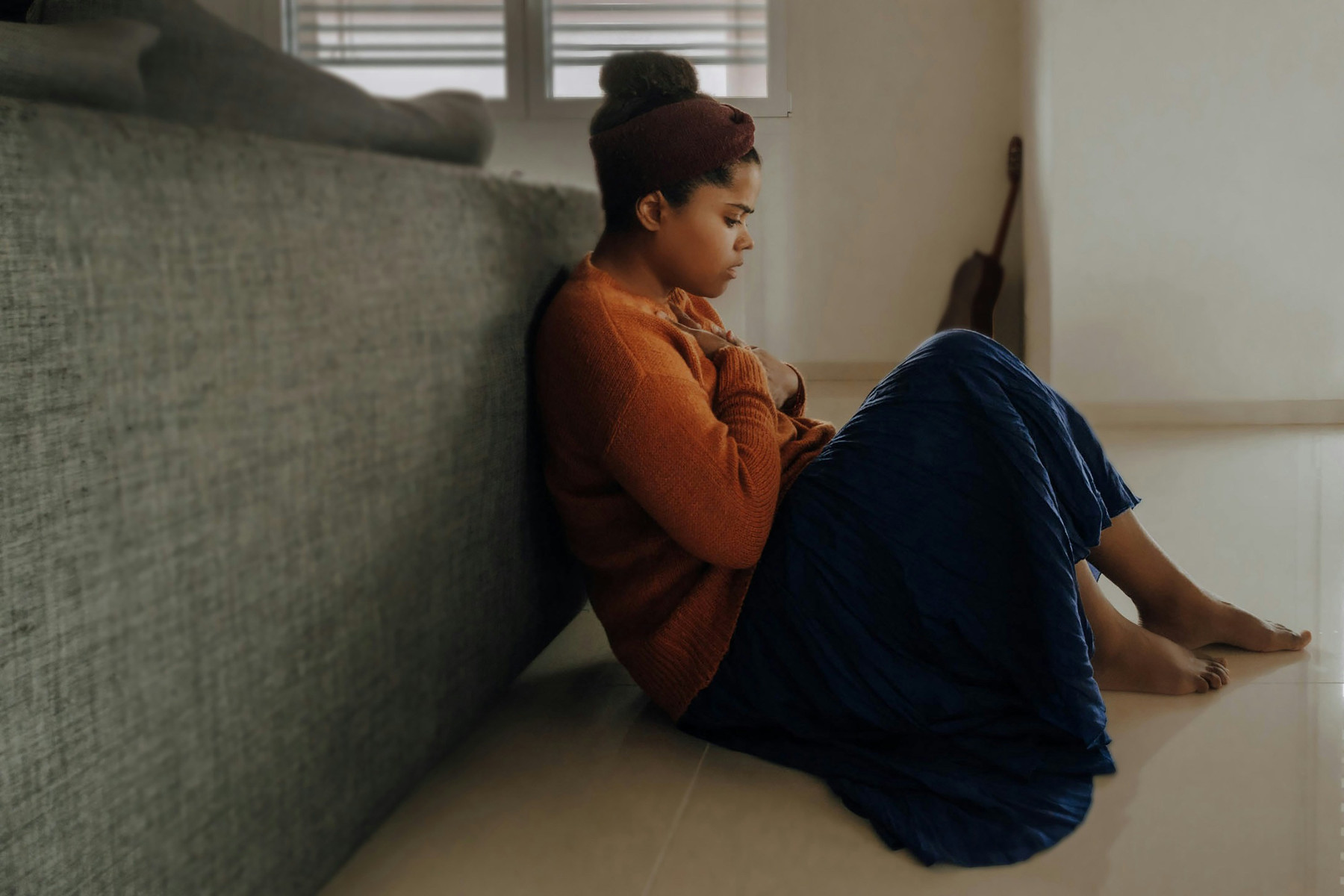woman sitting on the floor behind a couch