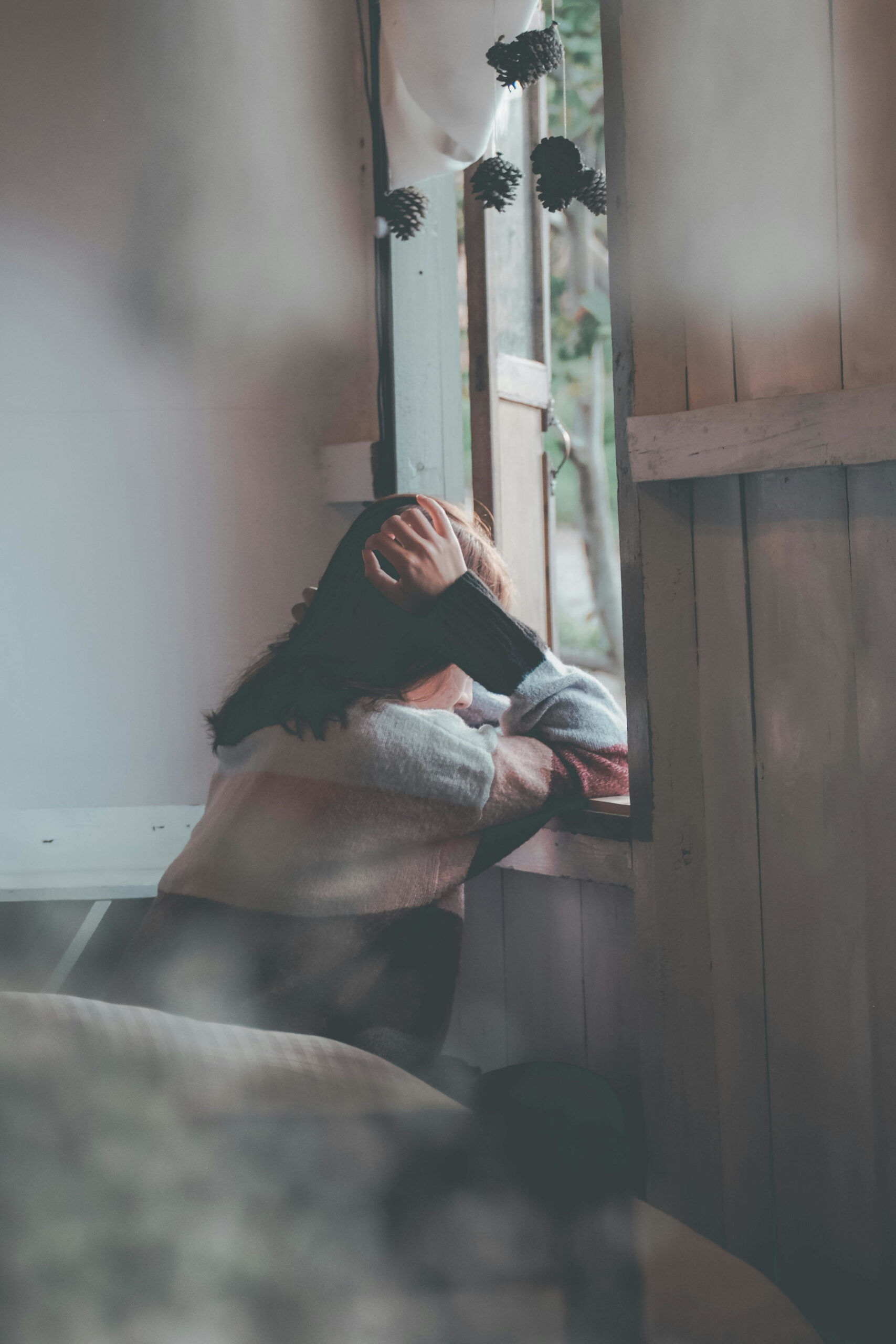woman sitting and looking outside a window